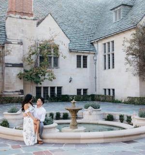 两名女子坐在建筑物前的喷泉上