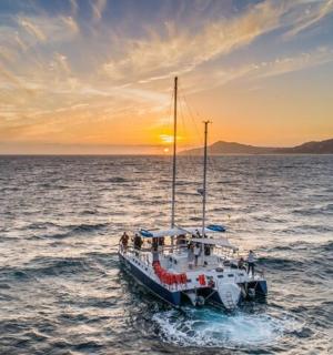 a boat in the ocean with the sunset in the background