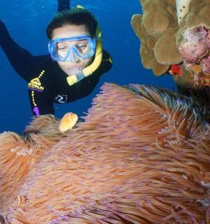 一名身穿潜水服的男子站在风速计旁边