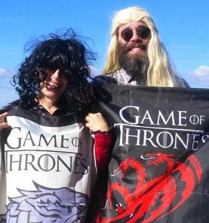 muž a žena držící ceduli s nápisem Hra o trůny