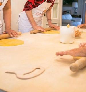一群人围着桌子站着,桌上放着面团