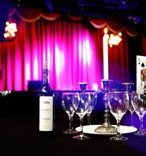 一瓶葡萄酒放在桌子上，还有酒杯