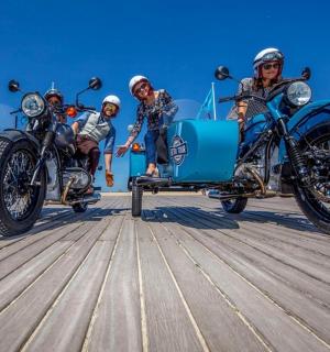a group of people riding motorcycles with a side car
