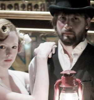 muž a žena stojící vedle muže držícího láhev