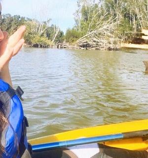 一名女子在皮划艇上看着水中的鲨鱼