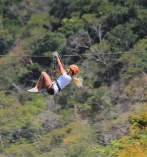 a woman flying through the air on a zip line