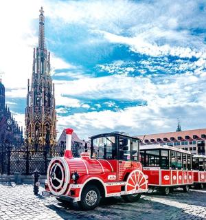 a red trolly car parked in front of a church
