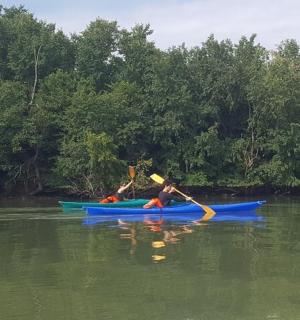 Dvě děti jsou v kajacích na řece
