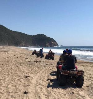 一群人在海滩上骑着四轮摩托车