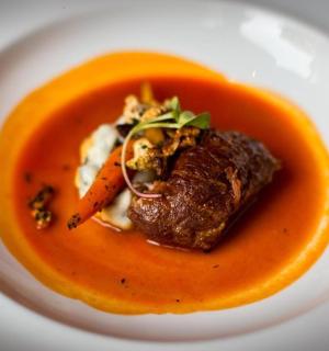 一碗汤,里面有一块肉和胡萝卜