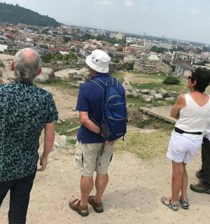 एक पहाड़ी की चोटी पर खड़े लोगों का एक समूह