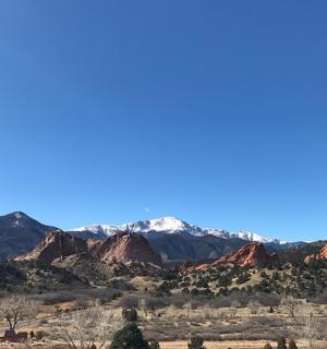 a view of the red rocks and snow capped mountains