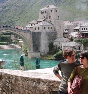 a man and a woman standing next to a bridge