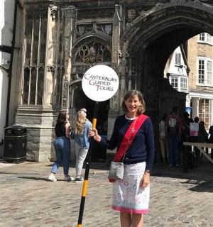 一名女子在建筑物前举着牌子