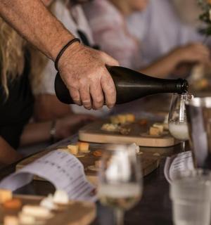 une personne versant une bouteille de vin sur une table