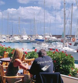 two people sitting at a table at a marina