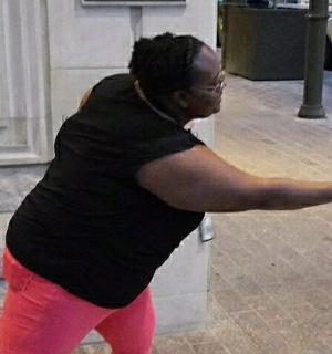 a woman standing on a sidewalk with her arms outstretched