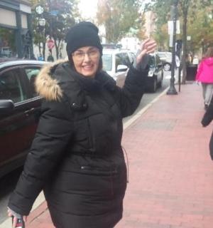 一名女子高举双手走在人行道上