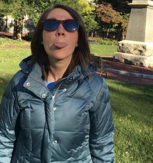 一位戴着太阳镜的女士站在公园里