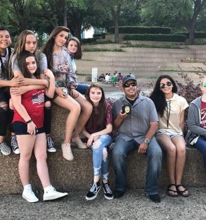 skupina lidí sedících na kamenné zdi