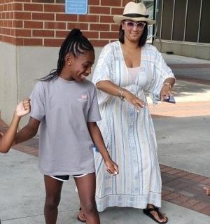 一名妇女和两个小孩站在人行道上