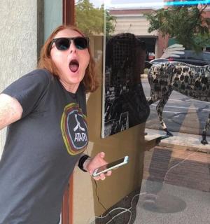 一名女子站在窗前，嘴巴张得大大的