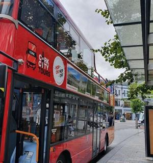 červený dvoupatrový autobus zaparkovaný na autobusové zastávce