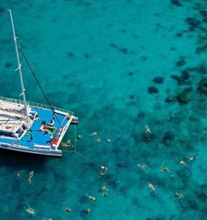 a blue boat in the water with people on it