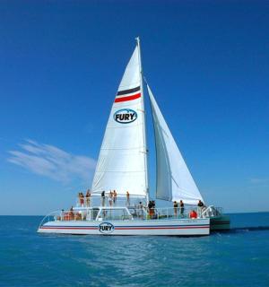 a group of people on a sail boat in the ocean