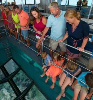 a group of people standing on the glass floor of a ship