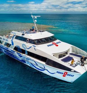 a white boat in the ocean with people on it