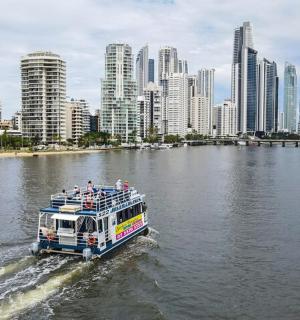a boat traveling down a river with a city