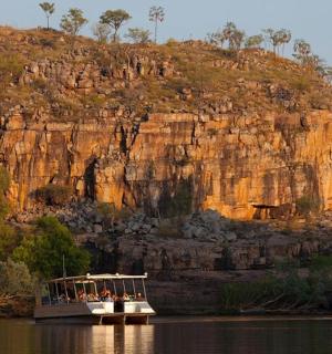 一艘载满人的船停在山边的水面上