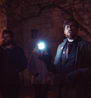 一名男子在黑暗的房间里拿着相机