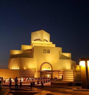 budova, před níž v noci stojí lidé