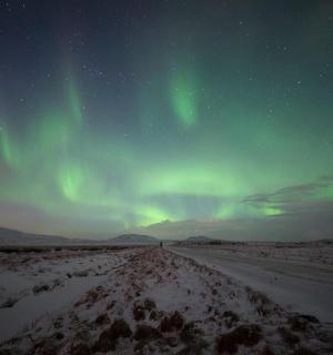 an image of the northern lights in the sky over a road