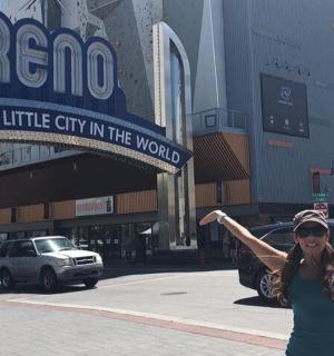 a woman with her arms in the air in a city