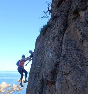 一名男子在海边攀爬岩壁