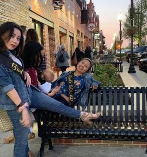 一名妇女抱着孩子坐在长凳上