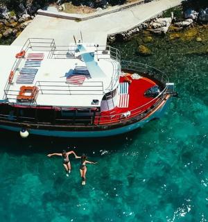 一名男子在船旁的水中游泳