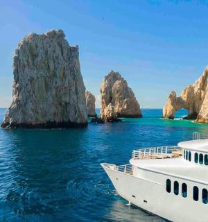 a boat in the water next to a rock formation