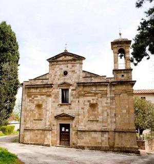 un vecchio edificio in pietra con una torre dell'orologio in cima
