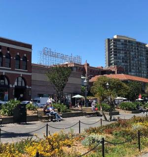 a park with people sitting on benches in front of a building
