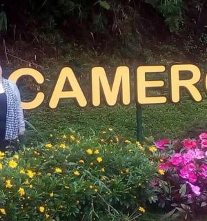 two people standing in front of a sign with flowers