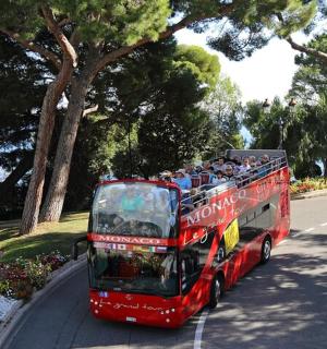 a red double decker bus driving down a street