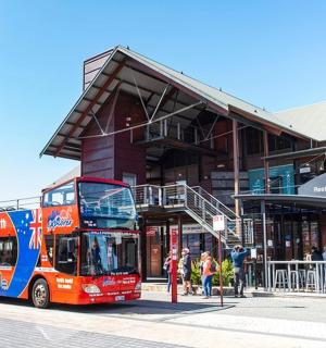 červený dvoupatrový autobus zaparkovaný před budovou