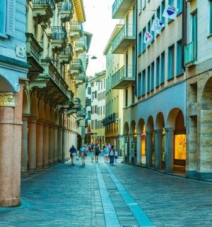 กลุ่มคนกำลังเดินไปตามถนนระหว่างอาคาร