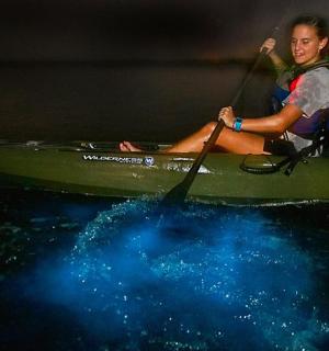 一名女子坐在水中的皮划艇上