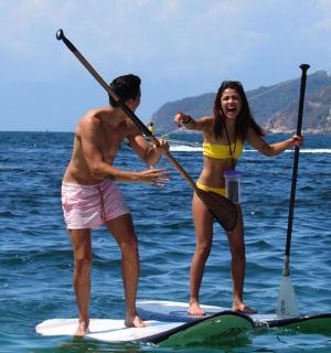 a man and a woman on a paddle board in the water