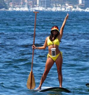 žena ve žlutých bikinách stojící na paddleboardu